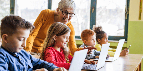 Teacher Helping Students on Computers