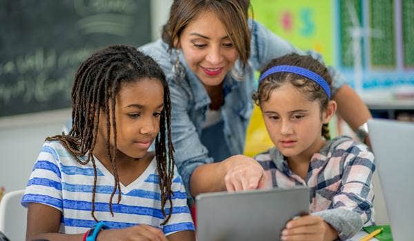 a parent + 2 kids look at a laptop